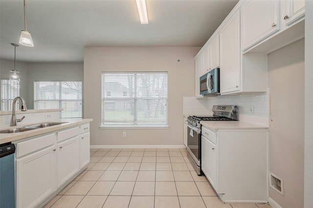 kitchen featuring visible vents, light tile patterned flooring, a sink, decorative backsplash, and stainless steel appliances