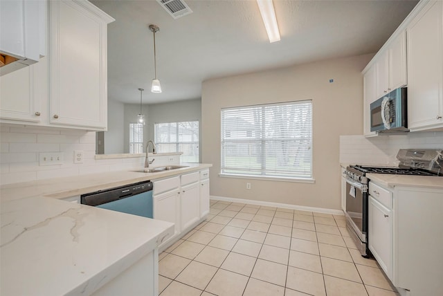 kitchen with light tile patterned floors, decorative backsplash, appliances with stainless steel finishes, white cabinets, and a sink