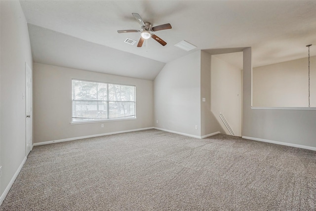 unfurnished room featuring visible vents, baseboards, vaulted ceiling, carpet flooring, and a ceiling fan