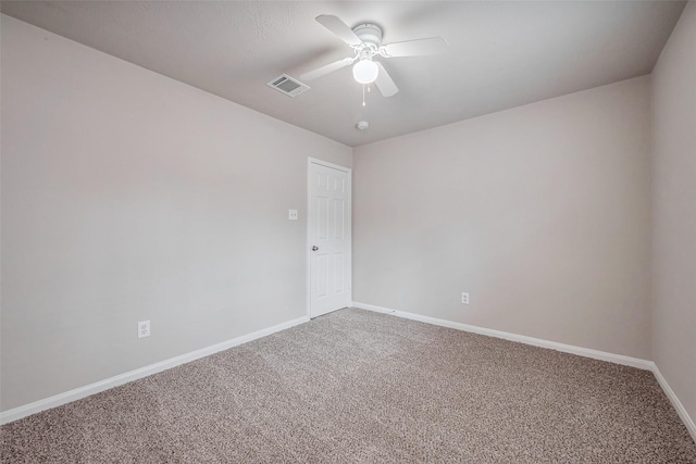 carpeted spare room featuring visible vents, baseboards, and ceiling fan