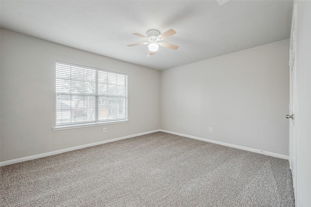 carpeted empty room with baseboards and a ceiling fan