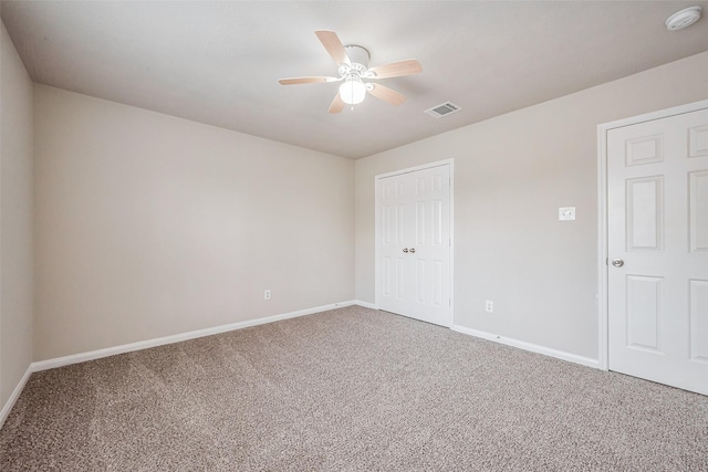 spare room with a ceiling fan, carpet, visible vents, and baseboards