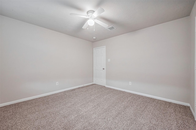 spare room with visible vents, light colored carpet, baseboards, and ceiling fan