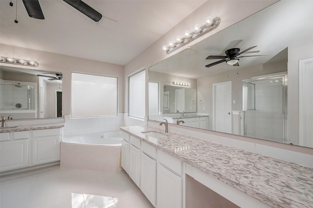 bathroom featuring a bath, a shower stall, a ceiling fan, and a sink