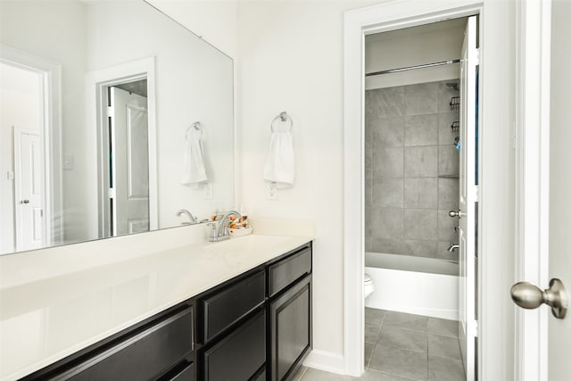 bathroom featuring toilet, washtub / shower combination, tile patterned flooring, baseboards, and vanity