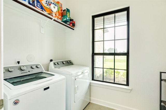 laundry room featuring laundry area, light tile patterned floors, baseboards, and independent washer and dryer