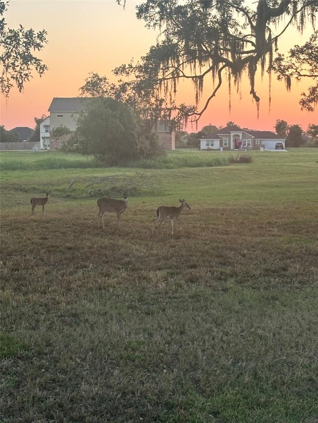 yard at dusk featuring a rural view