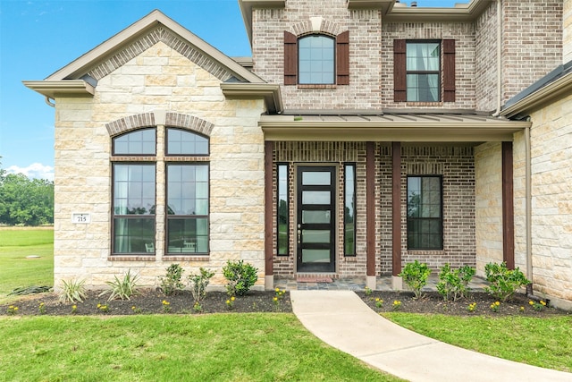 doorway to property featuring stone siding, metal roof, and a standing seam roof