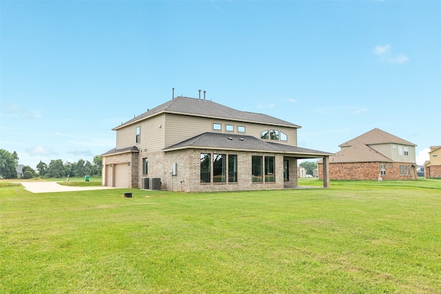 rear view of house with brick siding, central air condition unit, concrete driveway, a lawn, and an attached garage