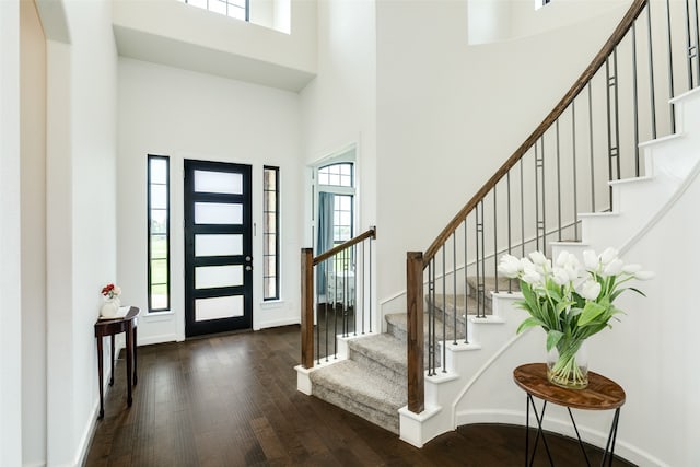 foyer with stairs, baseboards, a high ceiling, and dark wood-style flooring