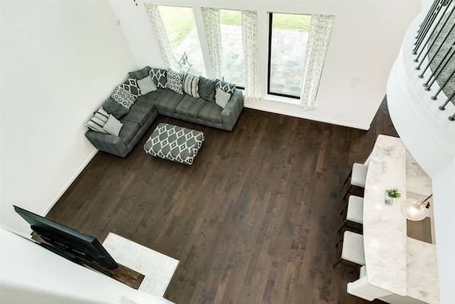 living area featuring stairs, wood finished floors, and baseboards