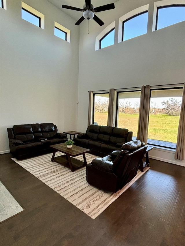 living area featuring ceiling fan, baseboards, and wood finished floors