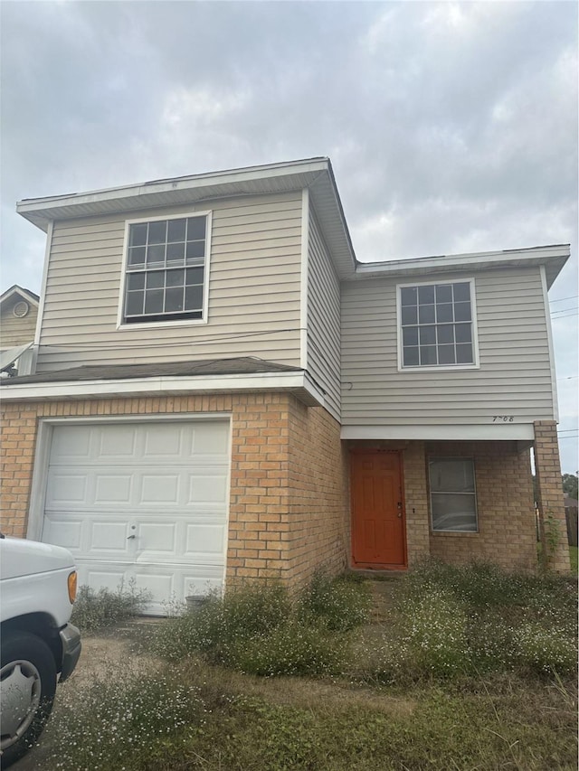 view of front of home with a garage and brick siding