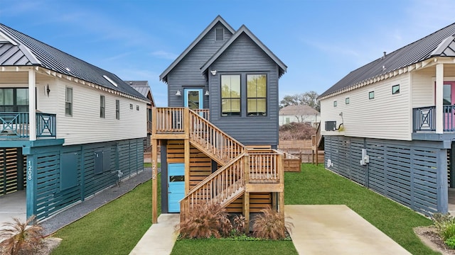 view of front of home with metal roof, stairway, a front lawn, and a standing seam roof