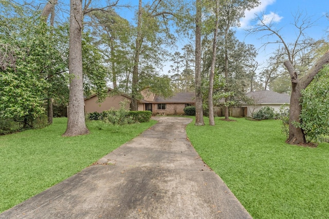 view of front of home featuring concrete driveway, brick siding, and a front lawn