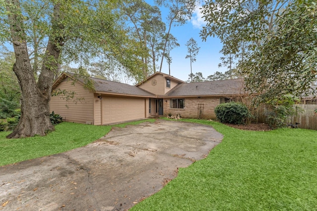 view of front of house with fence, concrete driveway, a front yard, an attached garage, and brick siding