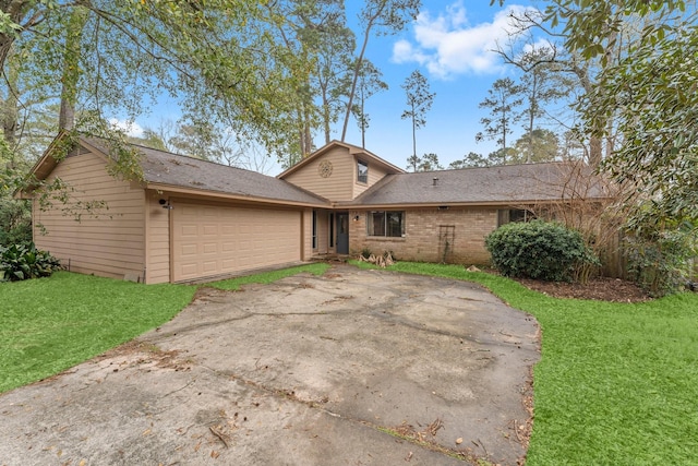 view of front of home featuring brick siding, concrete driveway, a garage, and a front yard