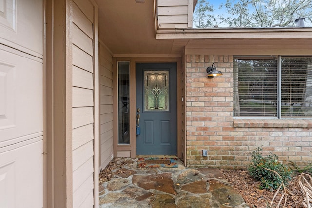 entrance to property featuring brick siding