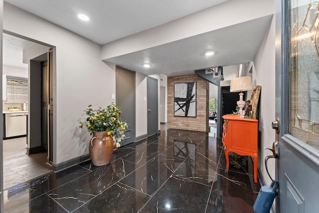 entrance foyer with recessed lighting, marble finish floor, a textured ceiling, and baseboards