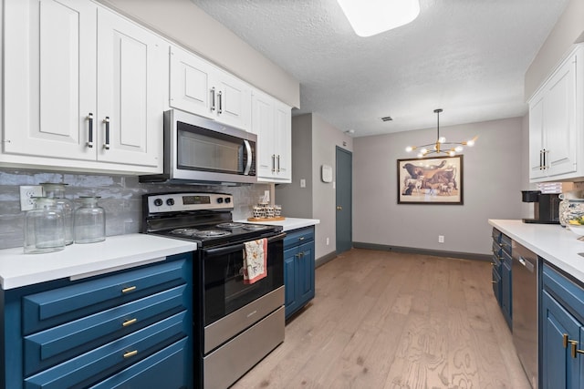 kitchen featuring light countertops, white cabinets, light wood-style floors, appliances with stainless steel finishes, and blue cabinets