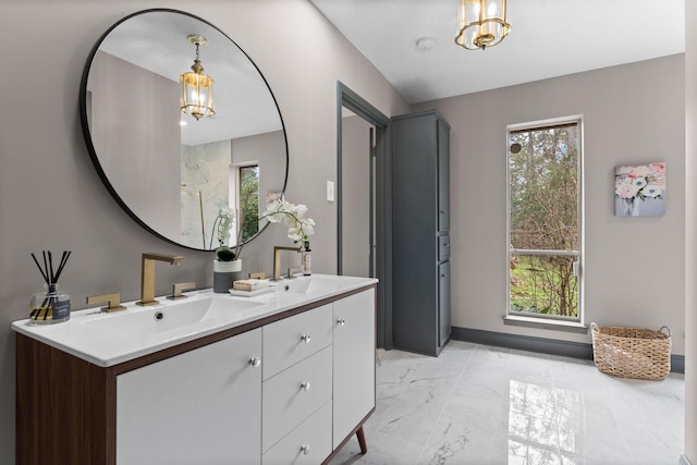 bathroom with double vanity, marble finish floor, a wealth of natural light, and a sink