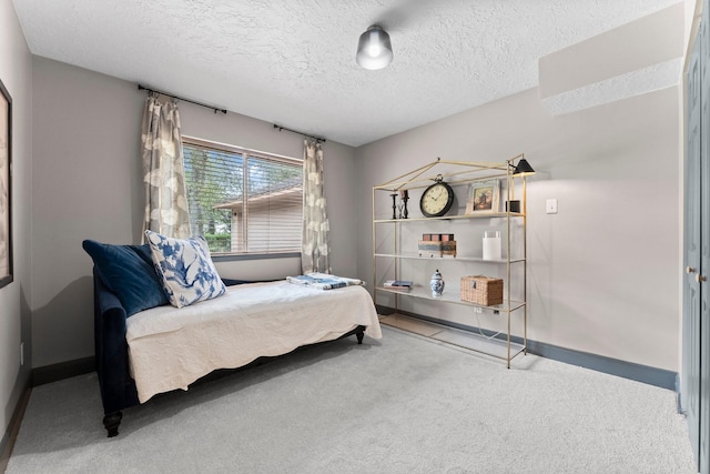 carpeted bedroom with a textured ceiling and baseboards