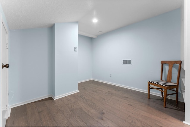 interior space featuring dark wood-style floors, visible vents, baseboards, recessed lighting, and a textured ceiling