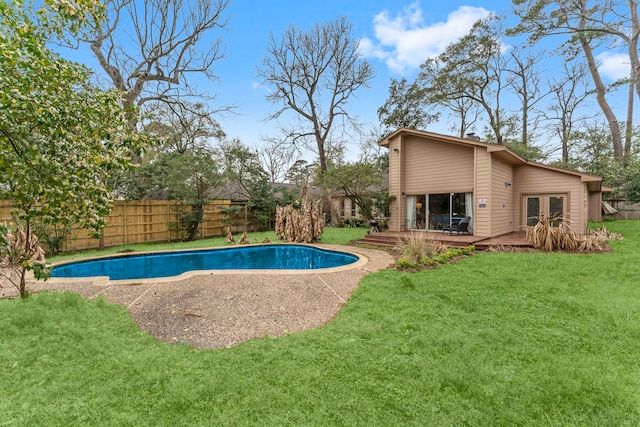 view of pool with a fenced in pool, a wooden deck, a fenced backyard, french doors, and a lawn