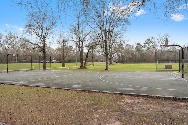 view of basketball court with community basketball court, a lawn, and fence