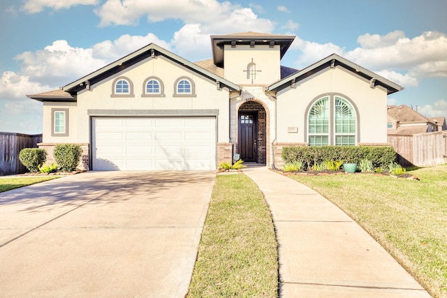 mediterranean / spanish home with stucco siding, concrete driveway, a front lawn, and fence