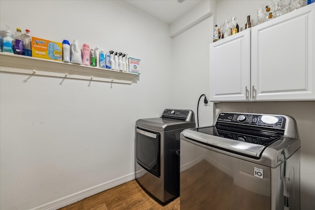 4113 Ella Blvd, Houston, TX 77018 - laundry room with wood finished floors, cabinet space, baseboards, and washing machine and clothes dryer