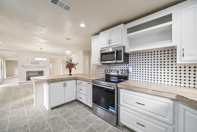 kitchen featuring visible vents, a peninsula, white cabinets, stainless steel appliances, and open shelves