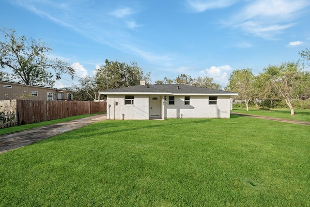 back of house featuring a yard, brick siding, and fence