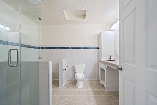 bathroom with tile patterned floors, toilet, a textured ceiling, a shower stall, and vanity