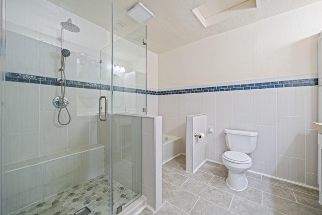 bathroom with tile patterned floors, toilet, a bath, and a stall shower