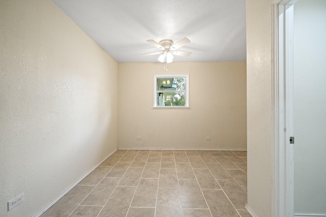 unfurnished room featuring a ceiling fan, baseboards, and a textured wall