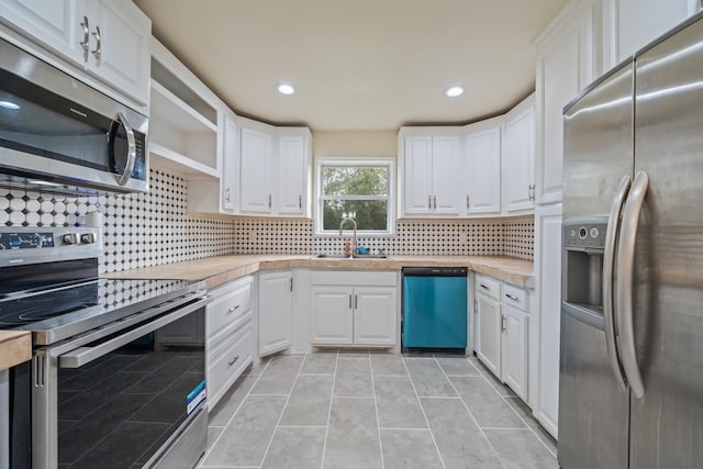 kitchen featuring a sink, open shelves, appliances with stainless steel finishes, and white cabinetry