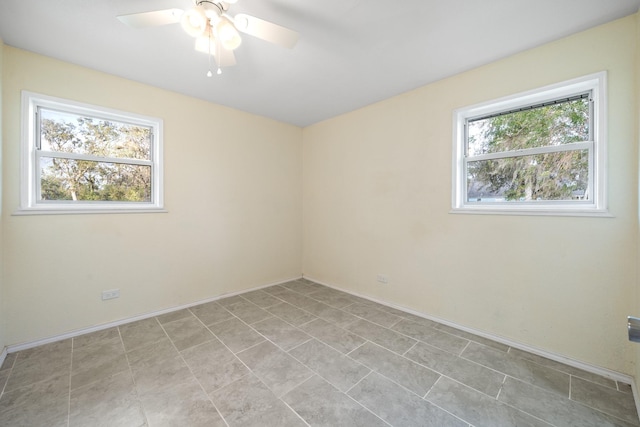 unfurnished room with a ceiling fan and baseboards