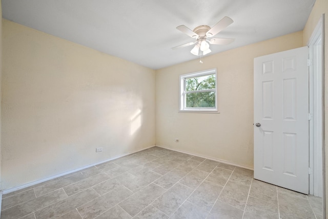 spare room featuring a ceiling fan and baseboards