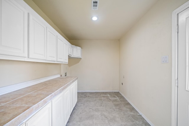 laundry area featuring visible vents, baseboards, washer hookup, recessed lighting, and cabinet space