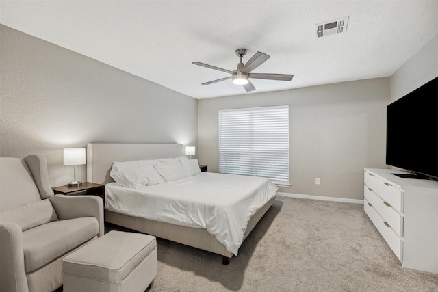 bedroom featuring a ceiling fan, light colored carpet, visible vents, and baseboards