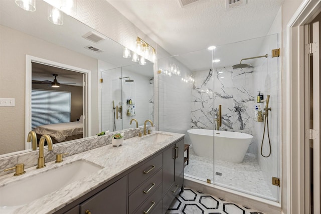 ensuite bathroom featuring double vanity, a stall shower, ensuite bath, and a sink