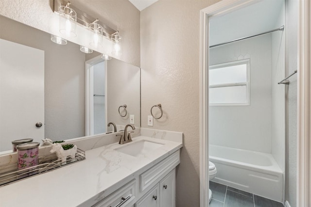 bathroom with vanity, tile patterned floors, toilet, and a textured wall