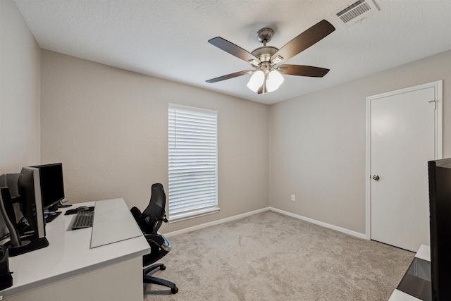 carpeted office space featuring a ceiling fan, visible vents, and baseboards