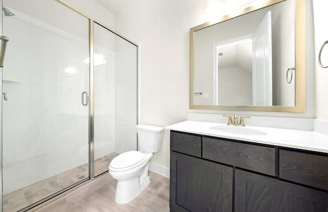 bathroom featuring toilet, a stall shower, and vanity