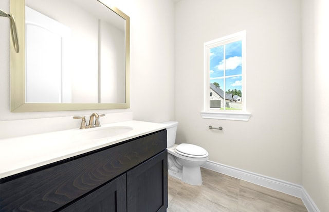 bathroom featuring baseboards, toilet, and vanity