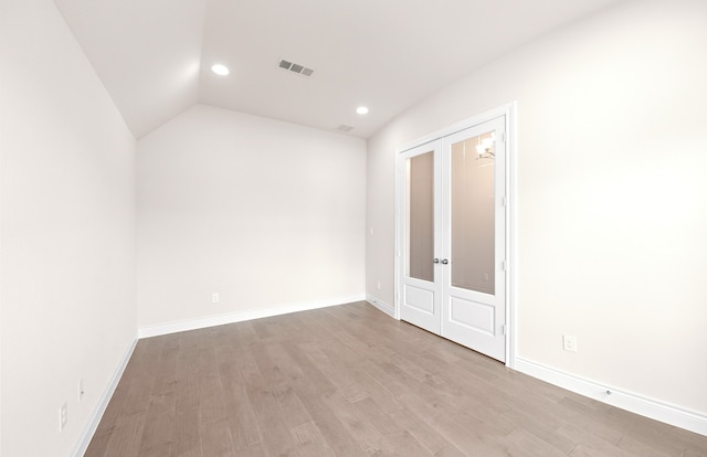 empty room featuring light wood-style floors, visible vents, french doors, and baseboards