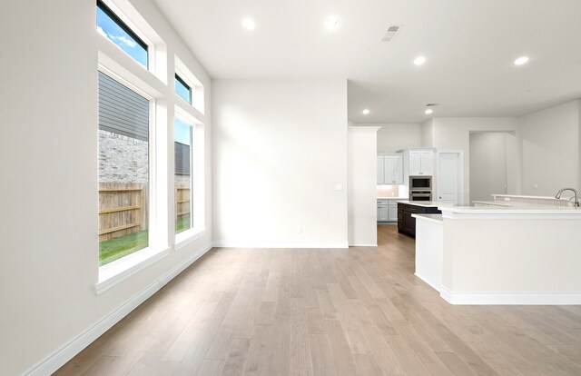 kitchen with baseboards, light countertops, recessed lighting, appliances with stainless steel finishes, and light wood-style floors