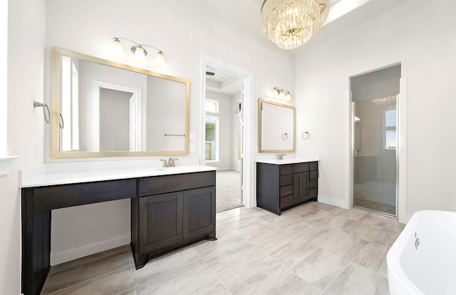 full bathroom with a soaking tub, a shower stall, two vanities, and a sink