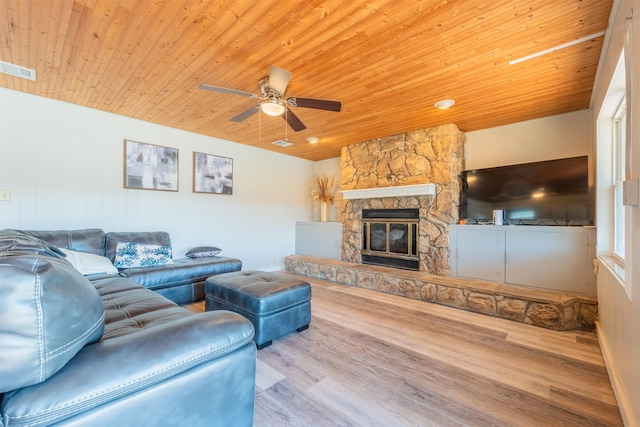 living area featuring visible vents, ceiling fan, a stone fireplace, wooden ceiling, and wood finished floors